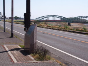 「渡良瀬橋の歌碑」と前方に見える「中橋」の写真です。