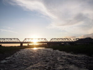 7月の夕日が沈む渡良瀬橋の写真です。