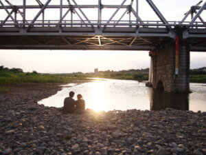 夏休み、渡良瀬橋で夕日を見る二人の写真です。