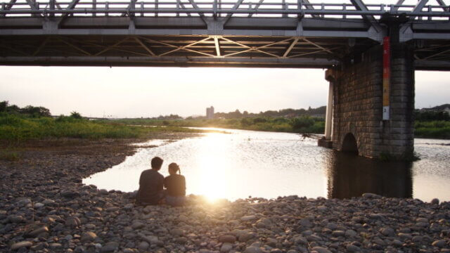 夏休み、渡良瀬橋で夕日を見る二人の写真です。