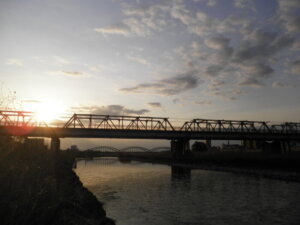 朝日を背景にした渡良瀬橋の写真です。