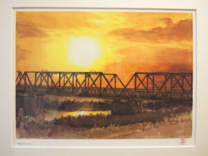 「渡良瀬橋の夕日」画家　長島喜一氏の作品です。