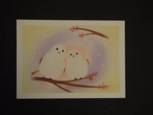 白い鳥が二羽、枝にとまって寄り添っているパステル画の写真です。