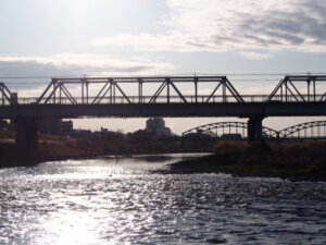 川面に映る朝日と「渡良瀬橋」の写真です。