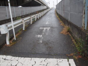 横断歩道を渡り、坂の歩道を上る写真です。