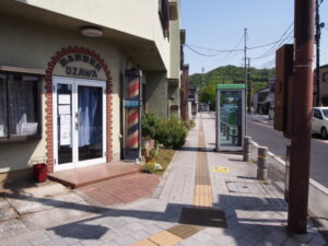 渡良瀬橋の歌詞にある床屋と公衆電話のある歩道の写真です。
