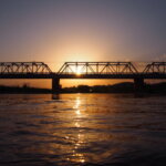 渡良瀬川に映る夕日と渡良瀬橋の写真です。