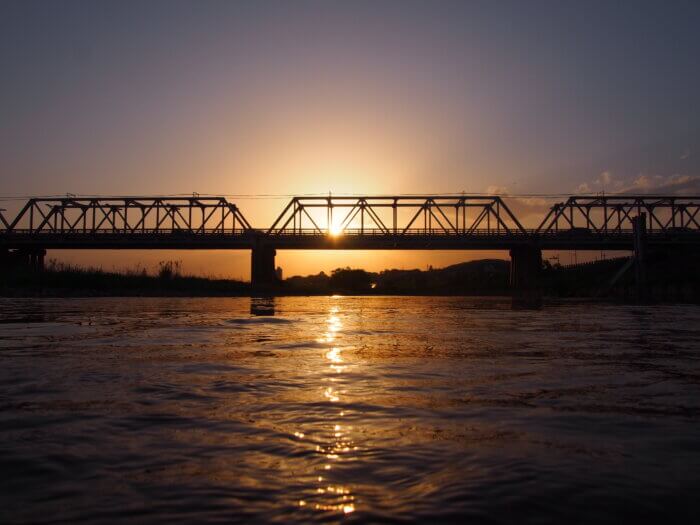 渡良瀬川に映る夕日と渡良瀬橋の写真です。
