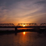 夕焼け空に包まれた渡良瀬橋の写真です。