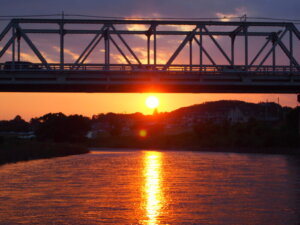 渡良瀬橋の下にかかる夕日の写真です。