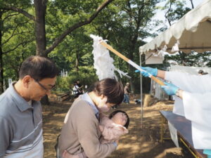 女浅間神社ペタンコ祭り：雄たらいをうける参拝者の写真です。