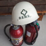 自主防災ヘルメットと消火器の写真です。