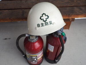 自主防災ヘルメットと消火器の写真です。