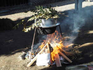 御厨神社・御筒粥祭：釜に乗せられた枝の写真です。