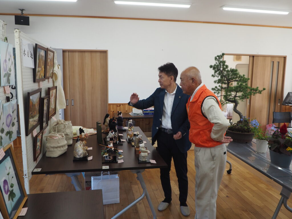 西新井町文化祭作品を鑑賞する足利市長と自治会長の写真です。