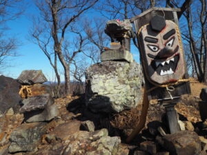 天狗山頂上にある祠と天狗のお面の写真です。