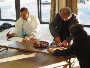 御厨神社・御筒粥祭：葦筒を開き入り具合を確認する写真です。