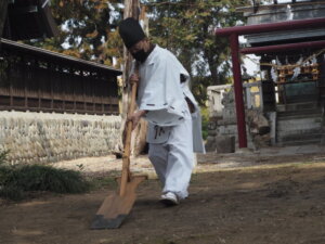 御厨神社御田植：スキで田を耕す所作の写真です。