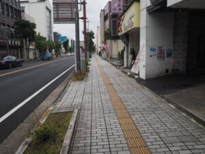 商店街が立ち並ぶ歩道の写真です。