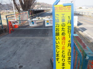 渡良瀬橋側道の工事延期の看板の写真です。