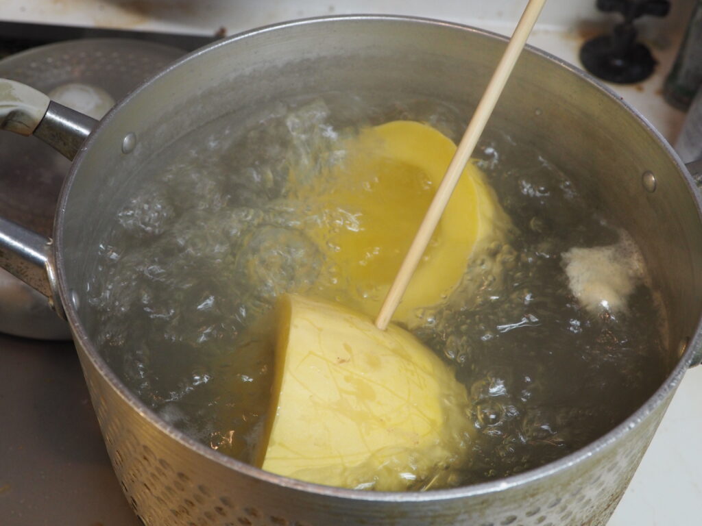 菜箸が刺さる程度まで茹でられたそうめんカボチャの写真です。