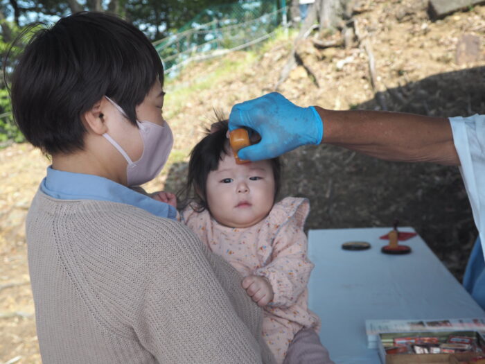 女浅間神社ペタンコ祭り:額に御朱印を押す写真です。