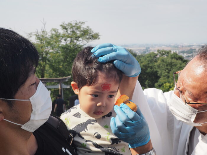 男浅間神社ペタンコ祭り:額に御朱印を押す写真です。