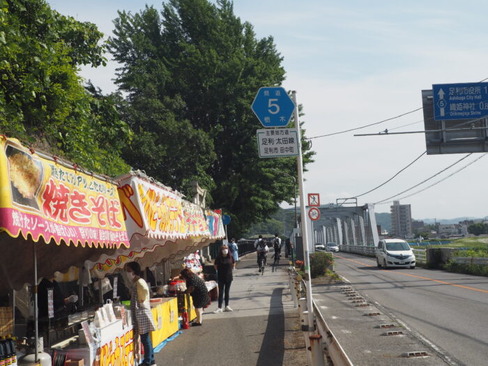 女浅間神社ペタンコ祭り:渡良瀬橋と屋台の写真です。